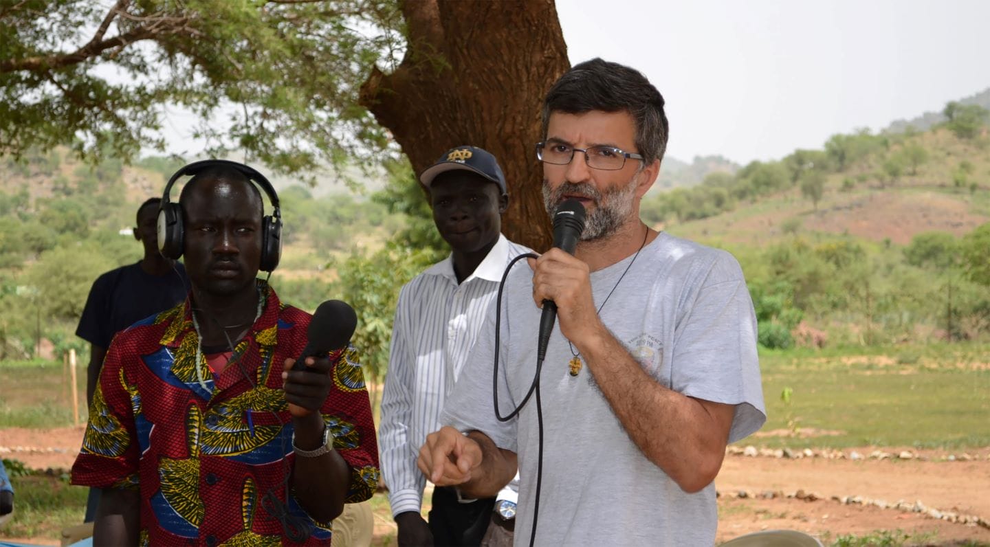 Fr. Alberto Lamana speaks under a mango tree