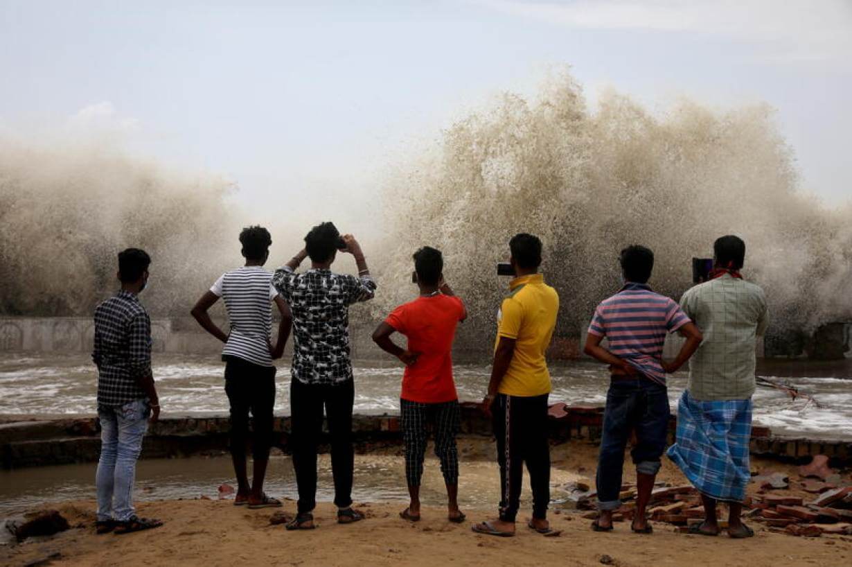 IndiaCycloneReutersBig A group of young people facing away from the camera. They are using their phones to record a monsoon rains.